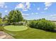 Backyard with artificial putting green, mature trees, and lush green grass at 10401 Maplebrook Way, Highlands Ranch, CO 80126