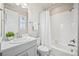 Bathroom featuring a shower-tub combo, vanity with a window and good lighting fixtures at 10401 Maplebrook Way, Highlands Ranch, CO 80126