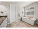 Bright bathroom featuring a soaking tub under a window and a stylish vanity with counter space at 10401 Maplebrook Way, Highlands Ranch, CO 80126