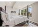 A bright bedroom features a four-poster bed, soft white linens, and large windows with natural light at 10401 Maplebrook Way, Highlands Ranch, CO 80126
