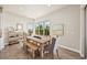 Bright dining area with a rustic wooden table, comfortable seating, and natural light streaming through large windows with green views at 10401 Maplebrook Way, Highlands Ranch, CO 80126