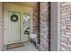 Inviting entryway with a decorative wreath on the front door and a cozy bench accented by a textured stone wall at 10401 Maplebrook Way, Highlands Ranch, CO 80126