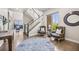 Bright foyer featuring hardwood floors, a staircase with black wrought iron spindles, and stylish decor with elegant seating at 10401 Maplebrook Way, Highlands Ranch, CO 80126