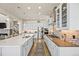 Bright kitchen boasts stainless appliances, sleek white cabinetry and quartz countertops at 10401 Maplebrook Way, Highlands Ranch, CO 80126