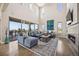 Sunlit living room with a cozy fireplace, plush seating, and expansive windows offering beautiful scenic views at 10401 Maplebrook Way, Highlands Ranch, CO 80126