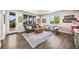 A comfortable living room boasts large windows, a plush sofa, and a rustic wooden coffee table at 10401 Maplebrook Way, Highlands Ranch, CO 80126
