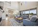 Open-concept living area with soaring ceilings, large windows offering picturesque views, and a gourmet kitchen in the background at 10401 Maplebrook Way, Highlands Ranch, CO 80126