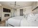 Bright main bedroom featuring a fireplace, ceiling fan, and sliding barn door to ensuite bath at 10401 Maplebrook Way, Highlands Ranch, CO 80126