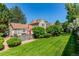 Manicured backyard with lush green lawn, mature trees, and a view of the home's exterior at 4676 S Dillon Ct # G, Aurora, CO 80015