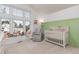 Bright Bedroom featuring large windows, a green accent wall, and a white crib at 4676 S Dillon Ct # G, Aurora, CO 80015
