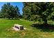 Park with a concrete bench seat under a large tree and a paved walkway in the background at 4676 S Dillon Ct # G, Aurora, CO 80015