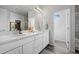 Bright bathroom featuring double sink vanity, gray wood floors and access to the closet at 4792 Coltin Trl, Castle Rock, CO 80104