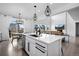 Open kitchen with island, stainless appliances, modern lighting, and view into the living room at 4792 Coltin Trl, Castle Rock, CO 80104
