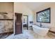 Bright bathroom features a soaking tub with a window and a separate tiled walk-in shower at 30722 Eldora Ct, Evergreen, CO 80439