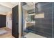 A luxurious bathroom features a glass-enclosed shower, navy tiling, and modern vanity, offering a spa-like experience at 135 Garnet St, Broomfield, CO 80020