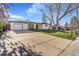 Wide view of a home with a large front lawn, driveway and detached garage at 135 Garnet St, Broomfield, CO 80020