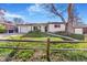 Charming white brick ranch with a well-manicured lawn, mature trees and a detached garage at 135 Garnet St, Broomfield, CO 80020