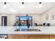 Kitchen island featuring a sink, modern faucet, and an open living space beyond at 135 Garnet St, Broomfield, CO 80020