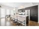 Modern kitchen boasts stainless steel appliances, quartz countertops, and large island with seating at 4395 Zuni St, Denver, CO 80211