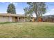Picturesque backyard with a wooden playset and ample green space for Gathering fun and relaxation at 3292 S Wabash Ct, Denver, CO 80231
