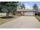 Ranch-style home with a brick exterior, driveway, and a large mature tree at 3292 S Wabash Ct, Denver, CO 80231