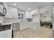 Well-lit kitchen featuring stainless steel appliances, white cabinets, and an adjacent dining area at 3292 S Wabash Ct, Denver, CO 80231