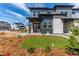Modern two-story home featuring stone accents, a covered entry, and a well-manicured lawn at 5773 N Jericho Way, Aurora, CO 80019