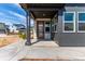 Inviting front porch with a stylish wood door, gray siding, and stone accents at 5773 N Jericho Way, Aurora, CO 80019