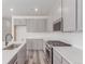 Modern kitchen featuring stainless steel appliances, gray cabinets, and white quartz countertops at 5773 N Jericho Way, Aurora, CO 80019