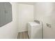 Well-lit laundry room featuring a modern washing machine and grey wood-look vinyl flooring at 9400 High St, Thornton, CO 80229