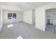 Bright living room featuring plush carpet, fresh white paint, and ample natural light from a large window at 9400 High St, Thornton, CO 80229