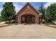 Exterior view of a brick clubhouse building featuring an arched entrance, flanked by green trees and manicured landscaping at 12820 Ironstone Way # 301, Parker, CO 80134