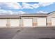 A row of garages with white doors and brick bases, set against a blue sky with scattered clouds on a paved lot at 12820 Ironstone Way # 301, Parker, CO 80134