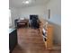 Cozy bonus room with hardwood floors and a built-in bookshelf along the stair railing at 58117 E 42Nd Dr, Strasburg, CO 80136