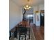 Charming dining room with wood floors, a classic chandelier, and an open view to the inviting living room at 58117 E 42Nd Dr, Strasburg, CO 80136