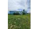 Charming blue home with green lawn and large mature bushes at 58117 E 42Nd Dr, Strasburg, CO 80136