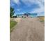 Inviting single-story home with covered front porch and attached two car garage, surrounded by a gravel yard at 58117 E 42Nd Dr, Strasburg, CO 80136