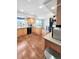 Open kitchen with wood cabinets, stainless appliances, and hardwood floors at 58117 E 42Nd Dr, Strasburg, CO 80136
