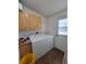 Bright laundry room featuring wooden floors, cabinets, washer, and dryer at 58117 E 42Nd Dr, Strasburg, CO 80136