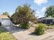 The property includes a detached garage and a driveway, with mature landscaping and a blossoming tree at 1568 S Osceola Way, Denver, CO 80219