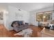 A bright living room features hardwood floors and lots of natural light with an open view to the dining area at 1568 S Osceola Way, Denver, CO 80219