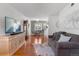 Bright living room featuring hardwood floors, a mounted TV, and an open dining area at 1568 S Osceola Way, Denver, CO 80219