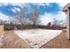 Large level backyard with rock border, new fencing, and partial snow coverage at 12569 S Sopris Creek Dr, Parker, CO 80134