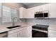 Bright kitchen features white cabinetry, stainless steel appliances, and granite countertops at 12569 S Sopris Creek Dr, Parker, CO 80134