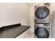 Modern laundry area with Samsung stacked washer and dryer and sleek countertop at 12569 S Sopris Creek Dr, Parker, CO 80134