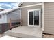 Home's patio features a sliding glass door with wooden railing along the concrete slab at 12569 S Sopris Creek Dr, Parker, CO 80134