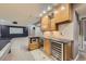 Modern basement wet bar with a wine fridge, microwave, stainless steel sink and glass shelving at 22911 E Euclid Cir, Aurora, CO 80016