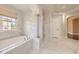 Luxurious bathroom features a soaking tub with marble surround, elegant columns, and marble flooring at 22911 E Euclid Cir, Aurora, CO 80016