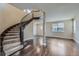 Elegant foyer features a curved staircase, hardwood floors, and abundant natural light from a large window at 22911 E Euclid Cir, Aurora, CO 80016