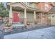 Charming front porch with a red door, brick accents, and decorative plants, inviting entry to the home at 22911 E Euclid Cir, Aurora, CO 80016